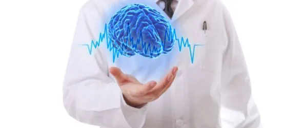 Lekarz trzyma świecący niebieski holograficzny mózg z nałożoną krzywą rytmu serca — symbol rehabilitacji neurologicznej